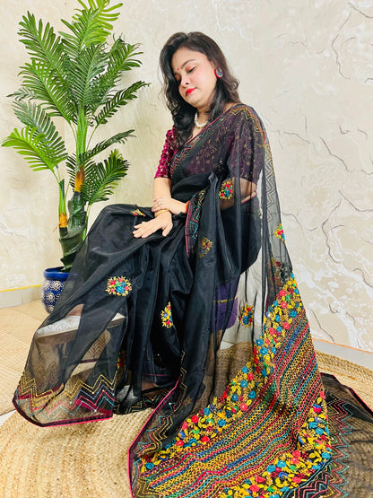 Woman sitting gracefully in handembroidered Black Organza Silk Saree with Bullion Stitch flowers and French knots — traditional saree look by Desi Aadat