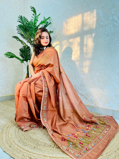 Woman seated in copper-brown handwoven Chanderi silk cotton saree with hand-stitched floral embroidery – Desi Aadat