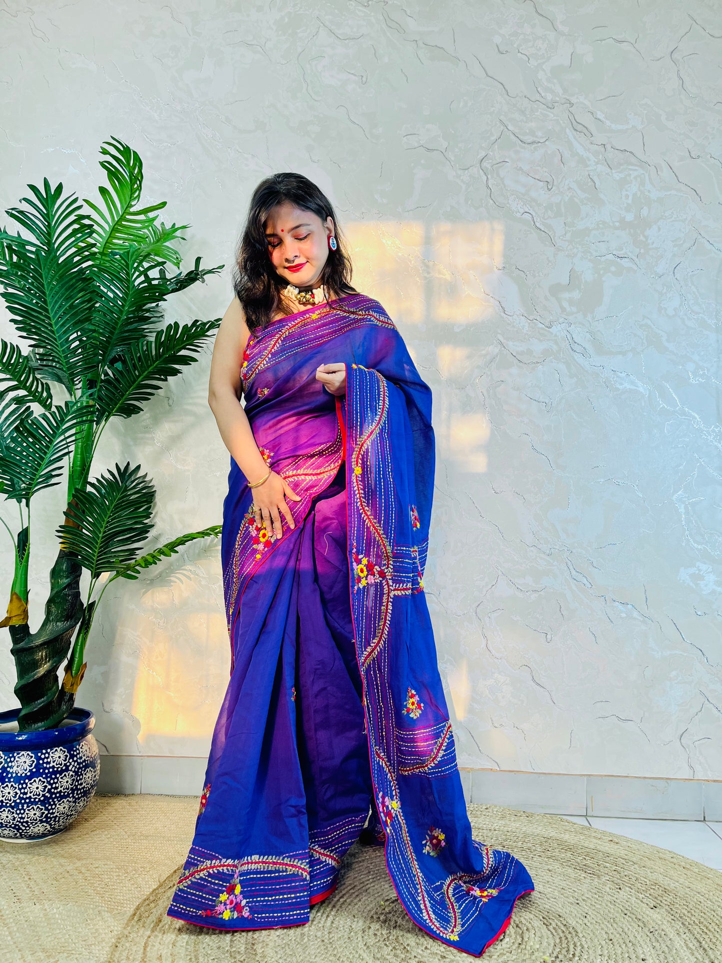 Side standing view of handwoven violet Chanderi silk cotton saree with bullion stitch and French knot floral work