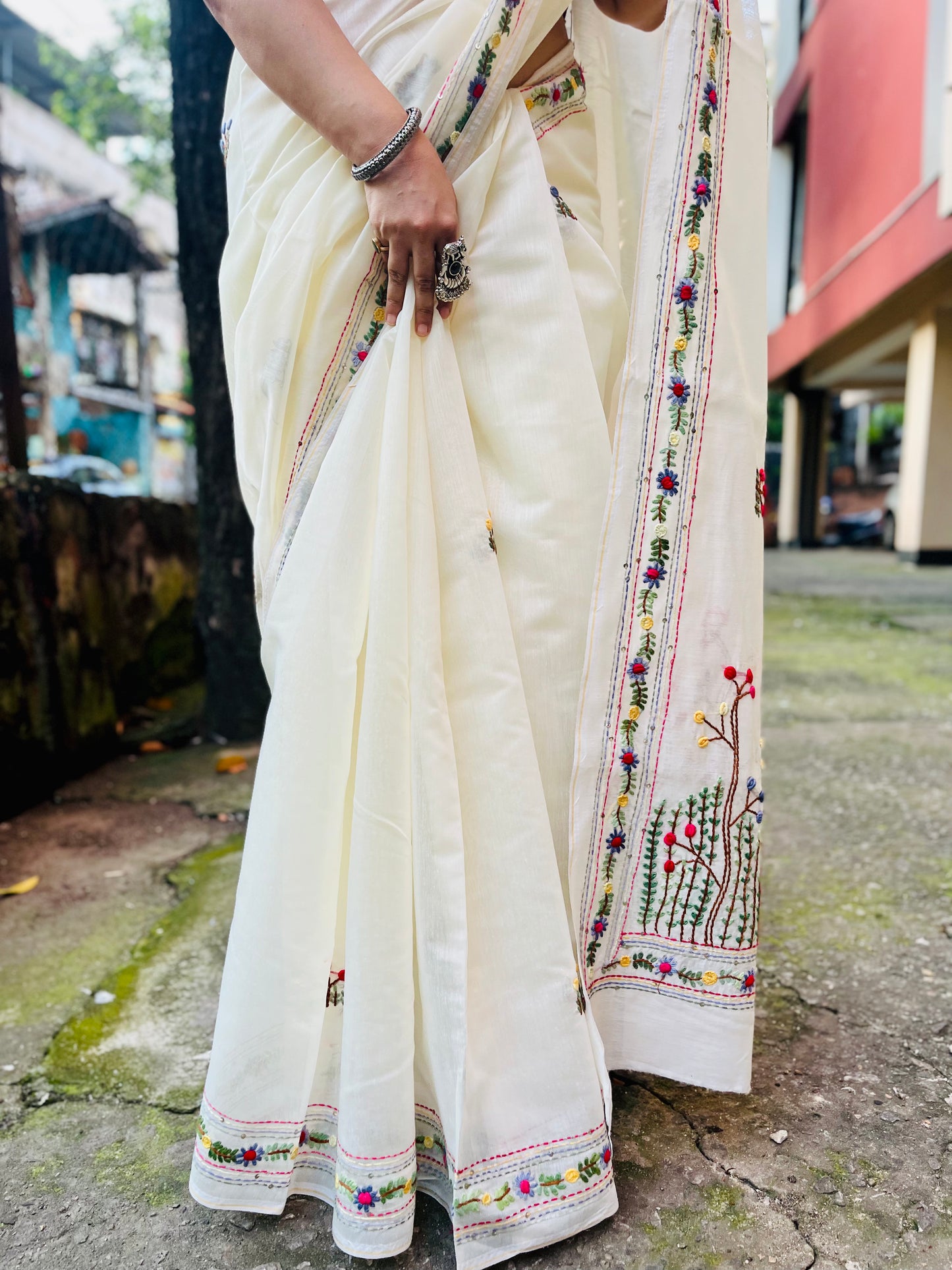Close-up of handcrafted Bullion Stitch and French Knot wildflower meadow embroidery on cream Chanderi silk cotton saree pallu — outdoor view, Desi Aadat
