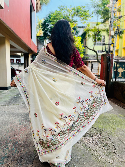 Back view of cream Chanderi silk cotton saree pallu showing dense Bullion Stitch and French Knot wildflower embroidery in flight — outdoor, Desi Aadat