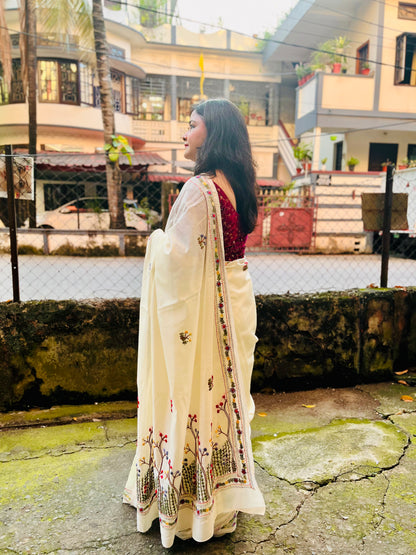 Back view of cream Chanderi silk cotton saree pallu showing dense Bullion Stitch and French Knot wildflower embroidery in flight — outdoor, Desi Aadat