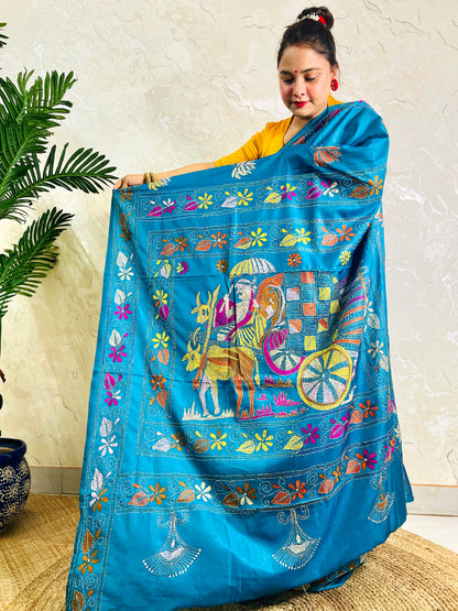 Back standing view of peacock blue Kantha stitch saree with floral border