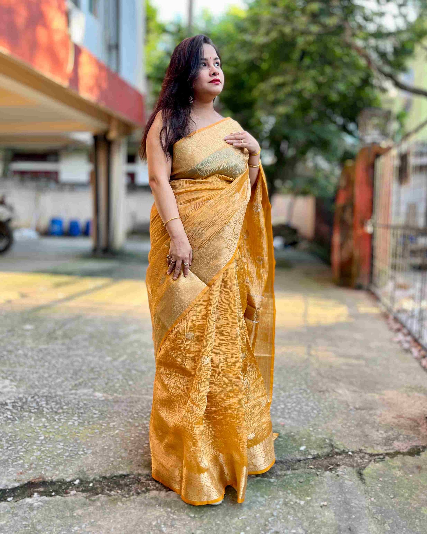 Elegant woman in Peach crush tissue saree showcasing Desi Aadat’s handwoven design
