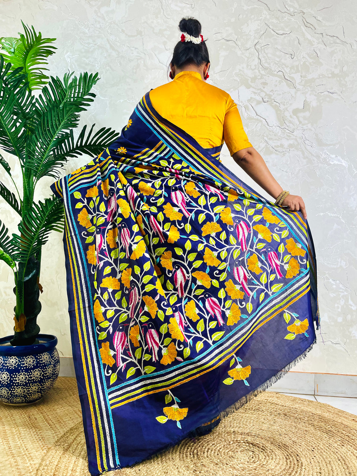 Navy blue Nakshi Kantha saree with bird and floral embroidery, back pallu standing view