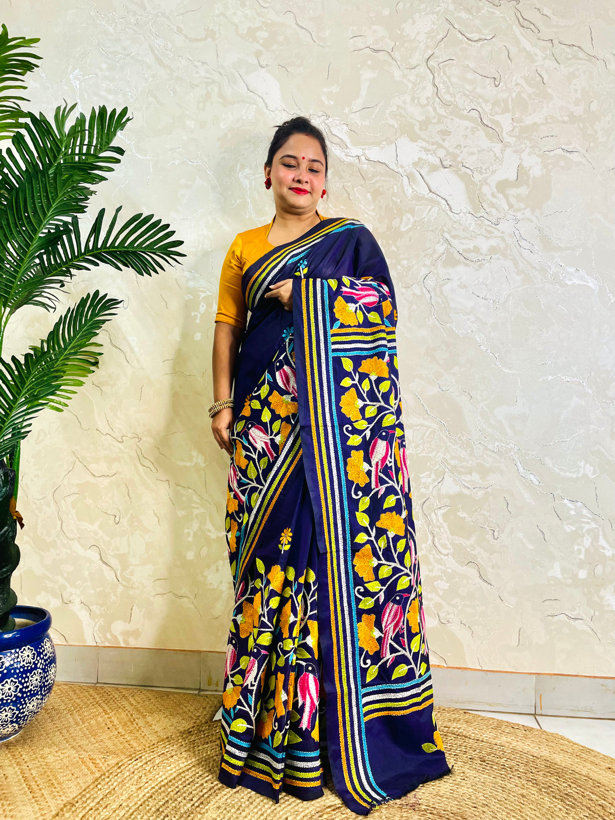 Front standing view of navy blue Kantha stitch saree with mustard bird motif