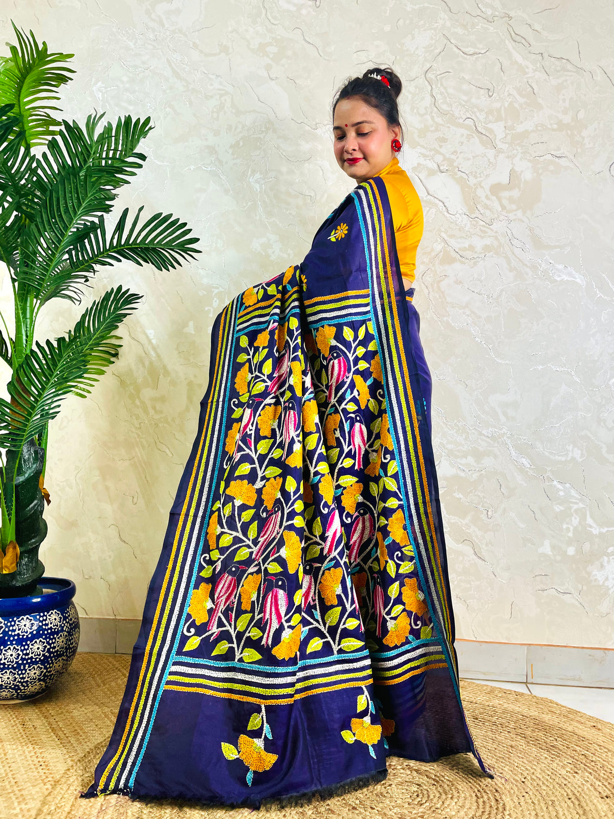 Front standing view of navy blue Kantha stitch saree with mustard bird motif