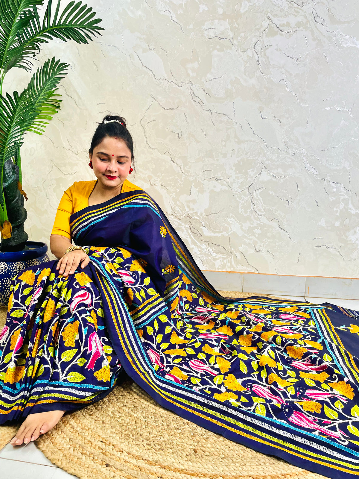 Woman draping navy blue Kantha stitch Bangalore silk saree with bird motif border