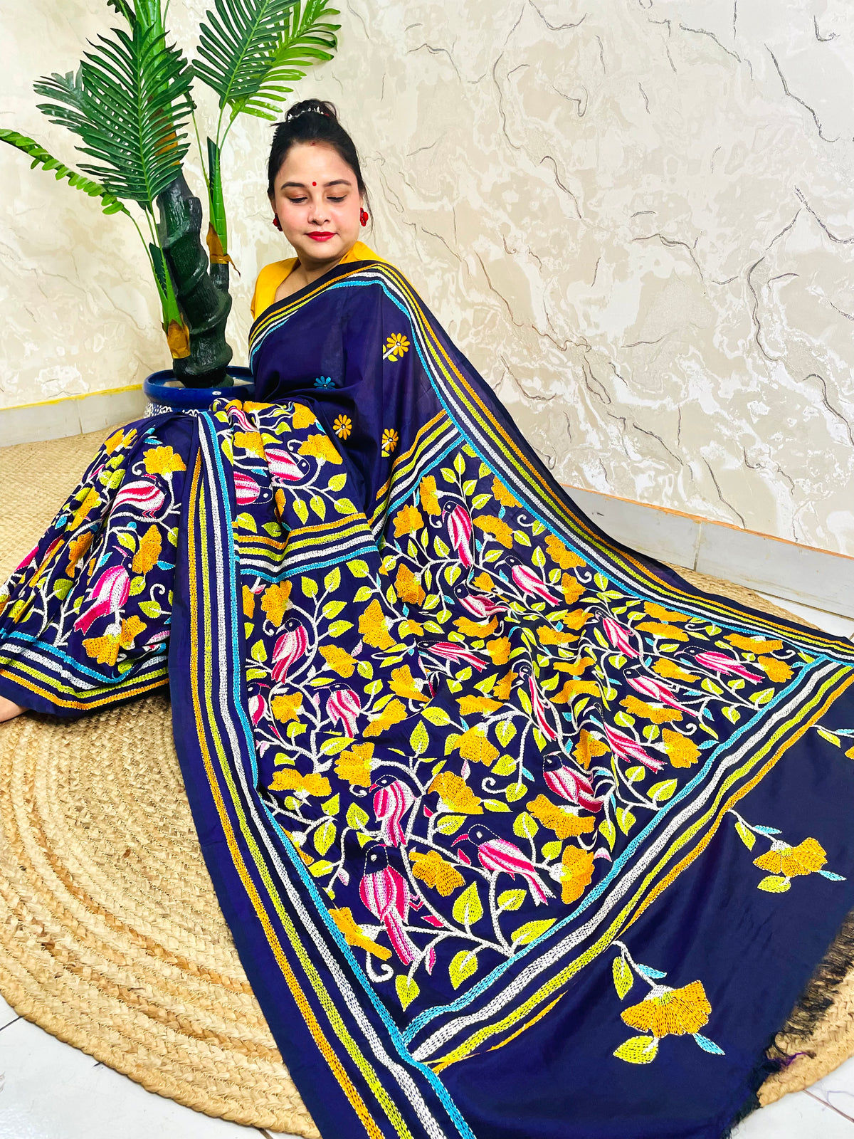 Woman draping navy blue Kantha stitch Bangalore silk saree with bird motif border