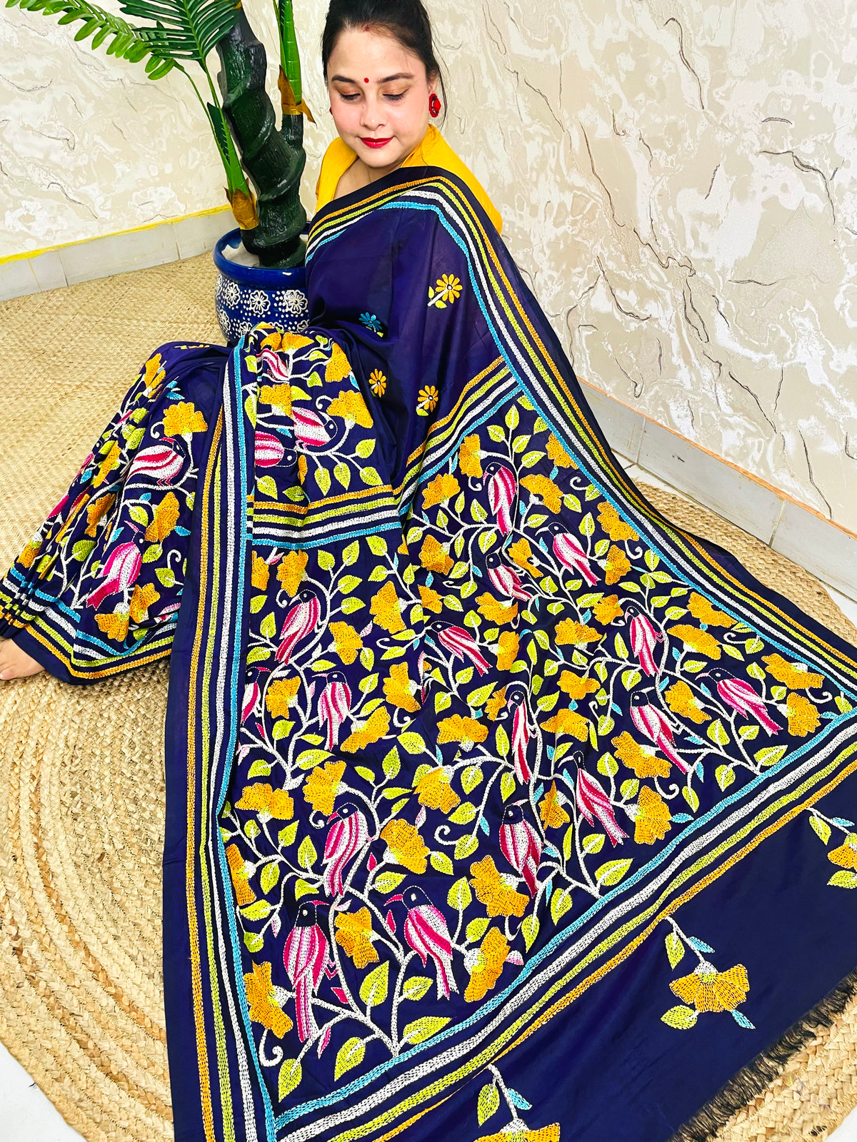 Woman draping navy blue Kantha stitch Bangalore silk saree with bird motif border