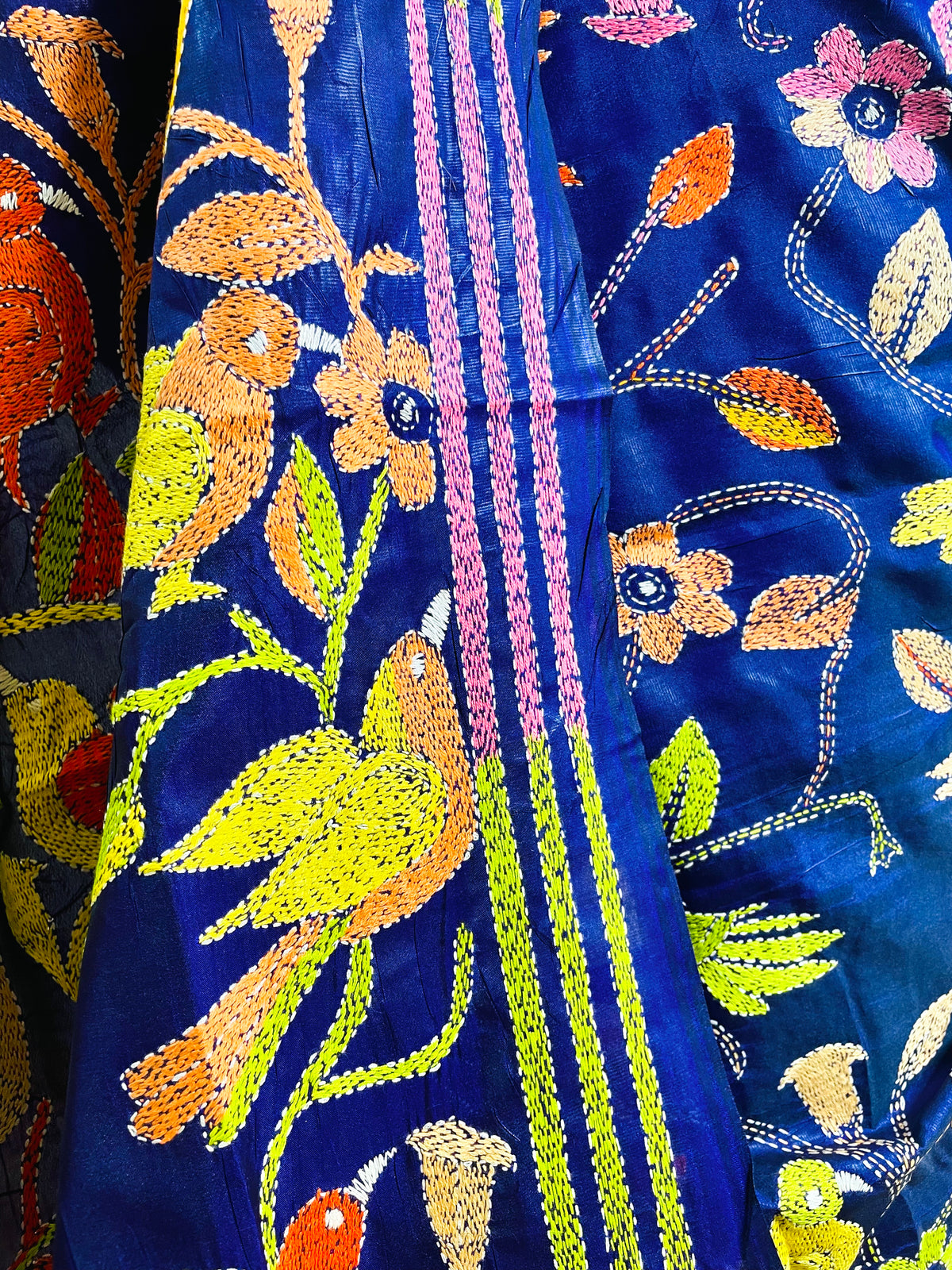 Detail view of gold and coral bird embroidery on royal blue Kantha stitch saree