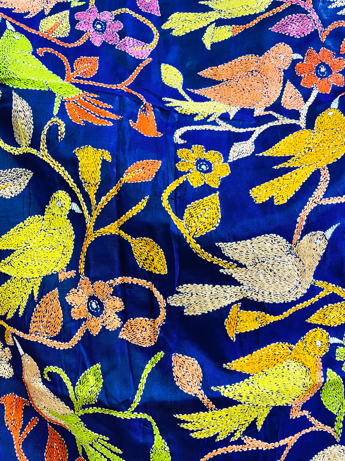 Close-up of hand-stitched Kantha birds and florals on royal blue Bangalore silk