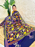 Woman seated in royal blue corner-to-corner Kantha silk saree, side pallu view