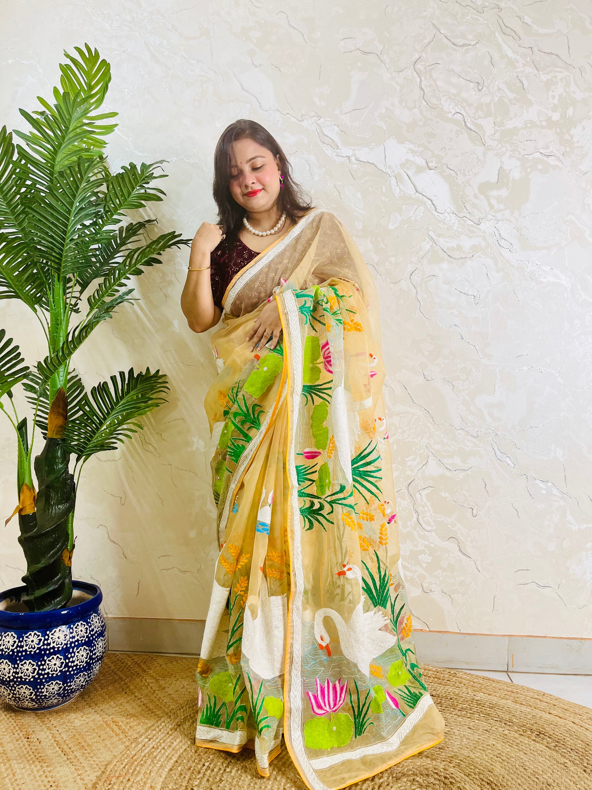 Beige gold organza saree with hansa swan and lotus motif, front standing view