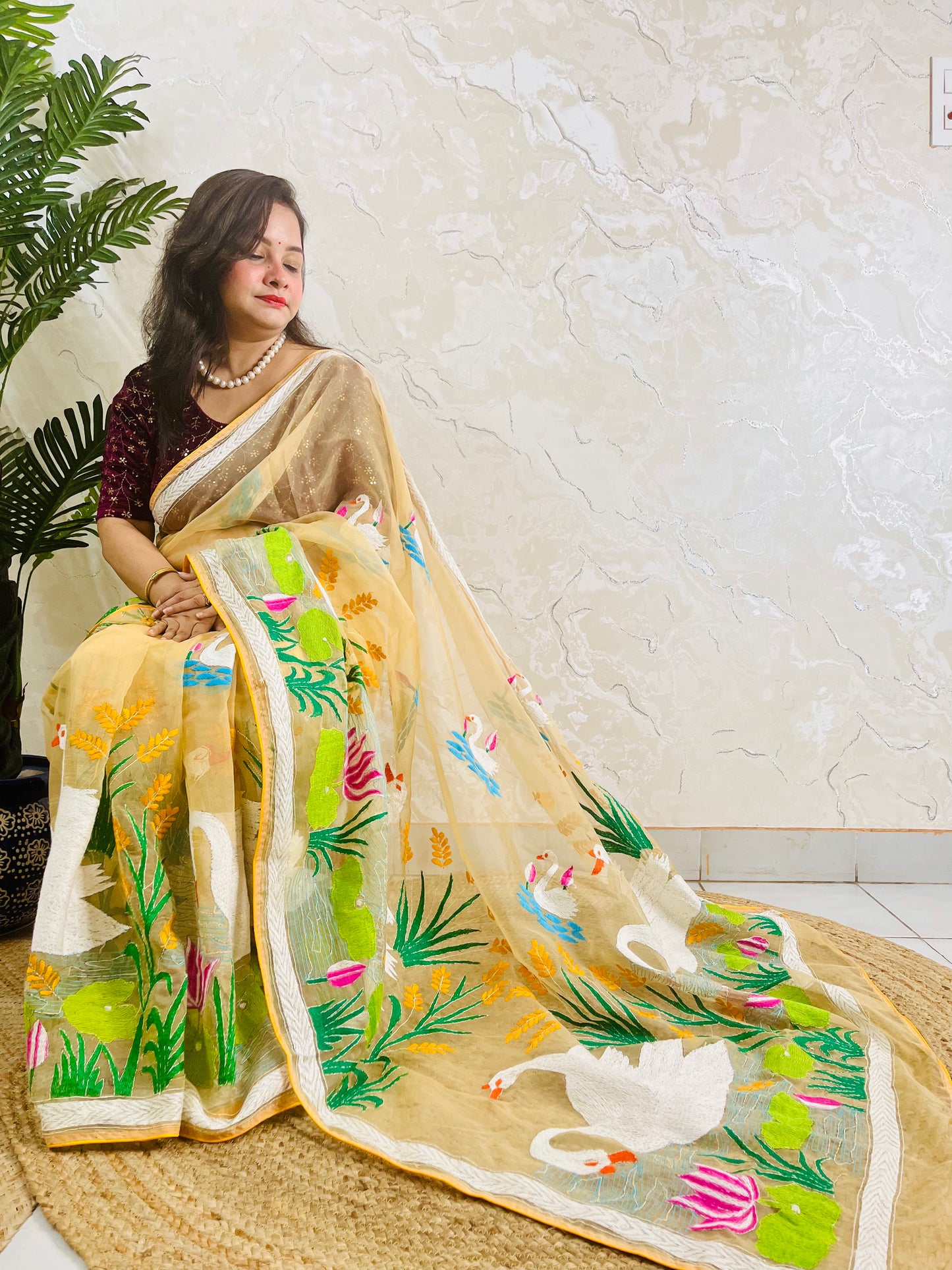 Beige gold Kantha stitch saree with swan and lotus embroidery, side seated view