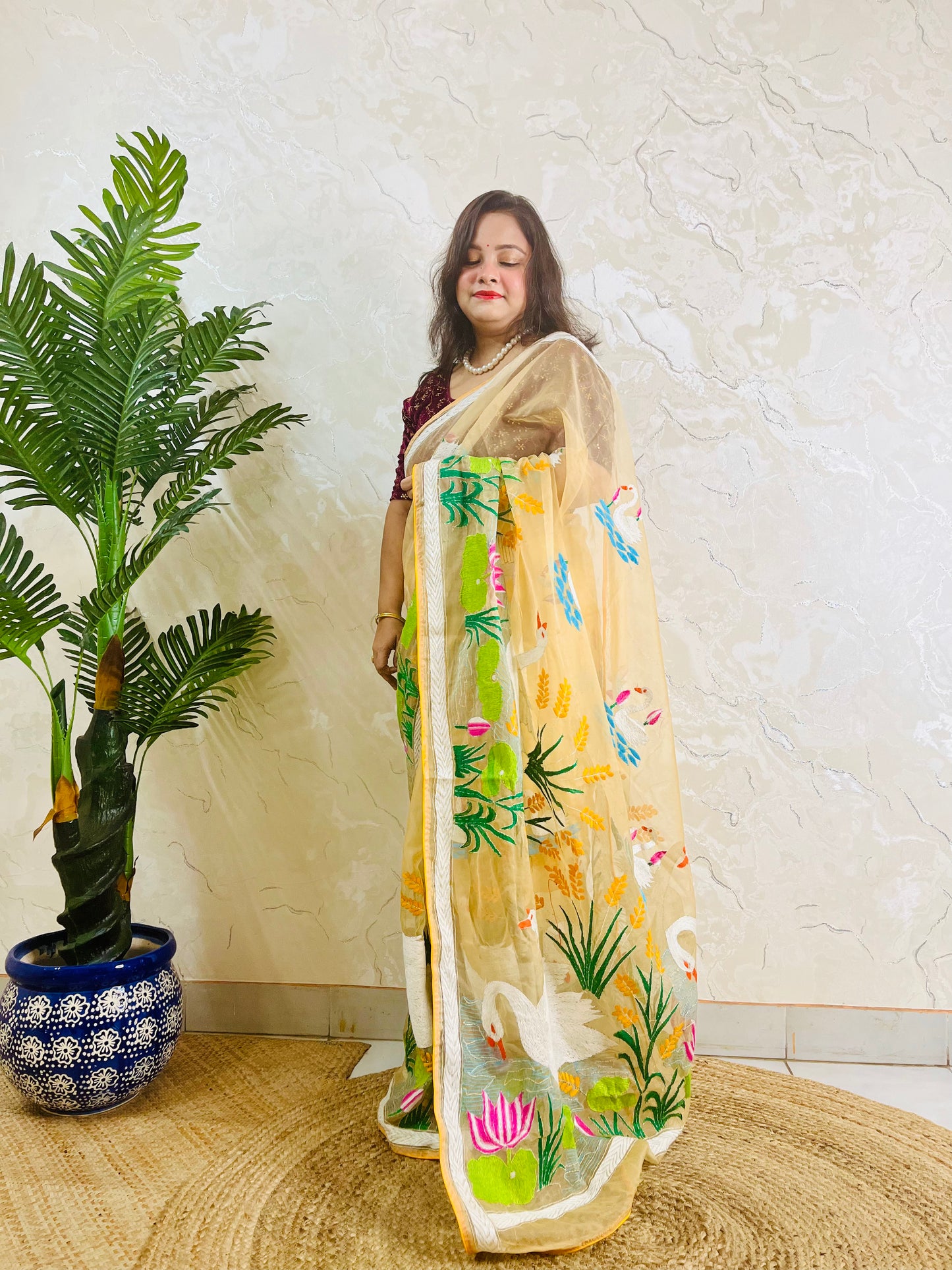 Beige gold organza saree with hansa swan and lotus motif, front standing view