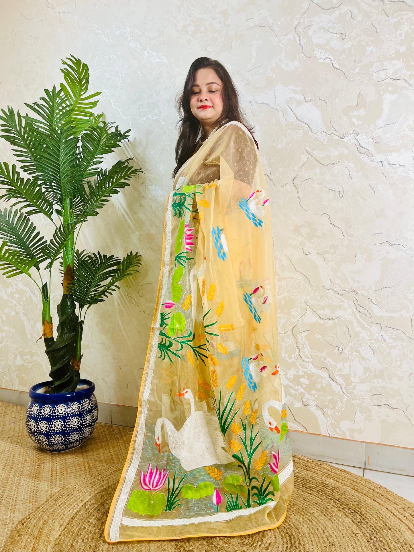 Beige gold organza saree with hansa swan and lotus motif, front standing view