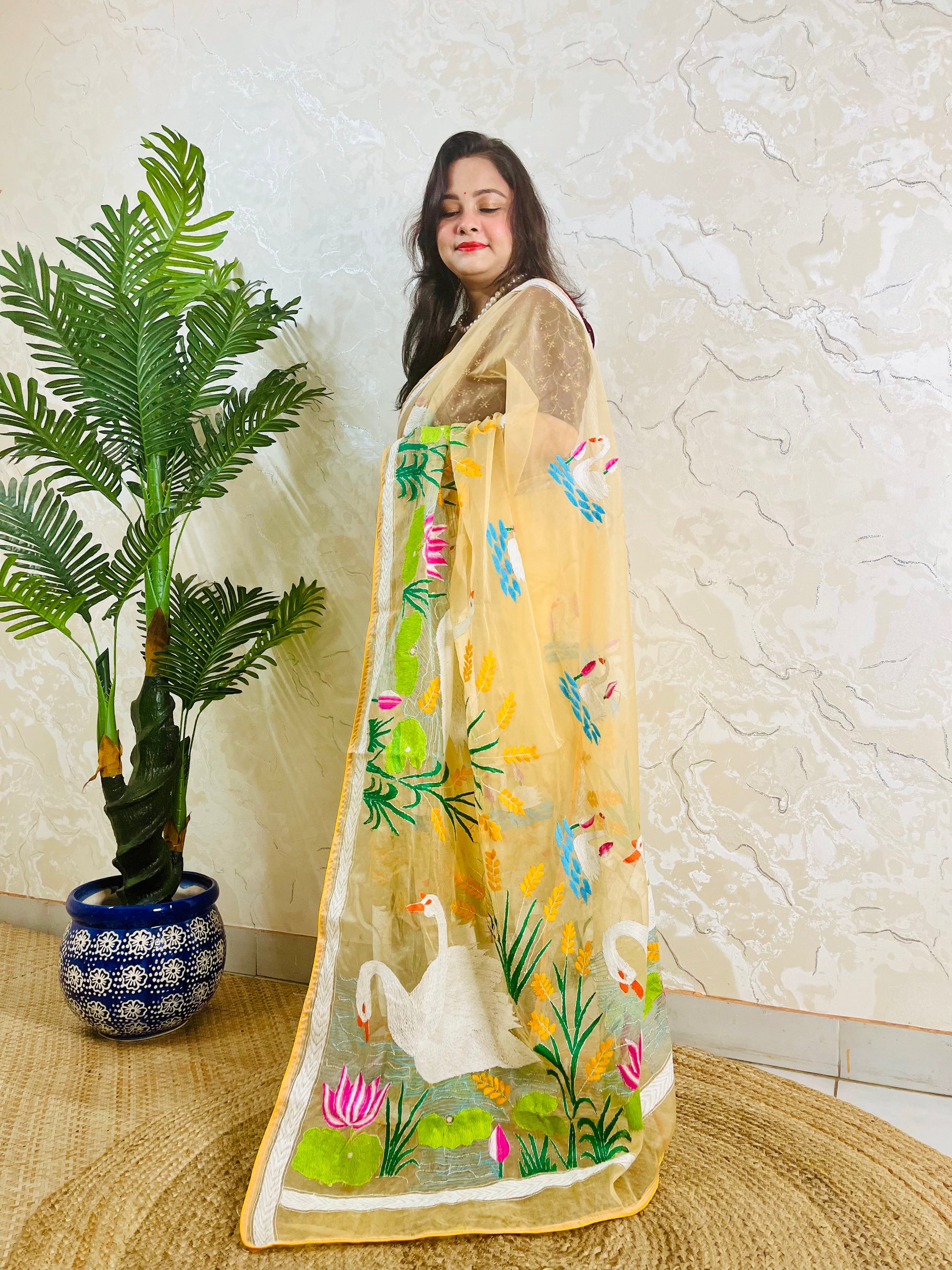 Beige gold organza saree with hansa swan and lotus motif, front standing view