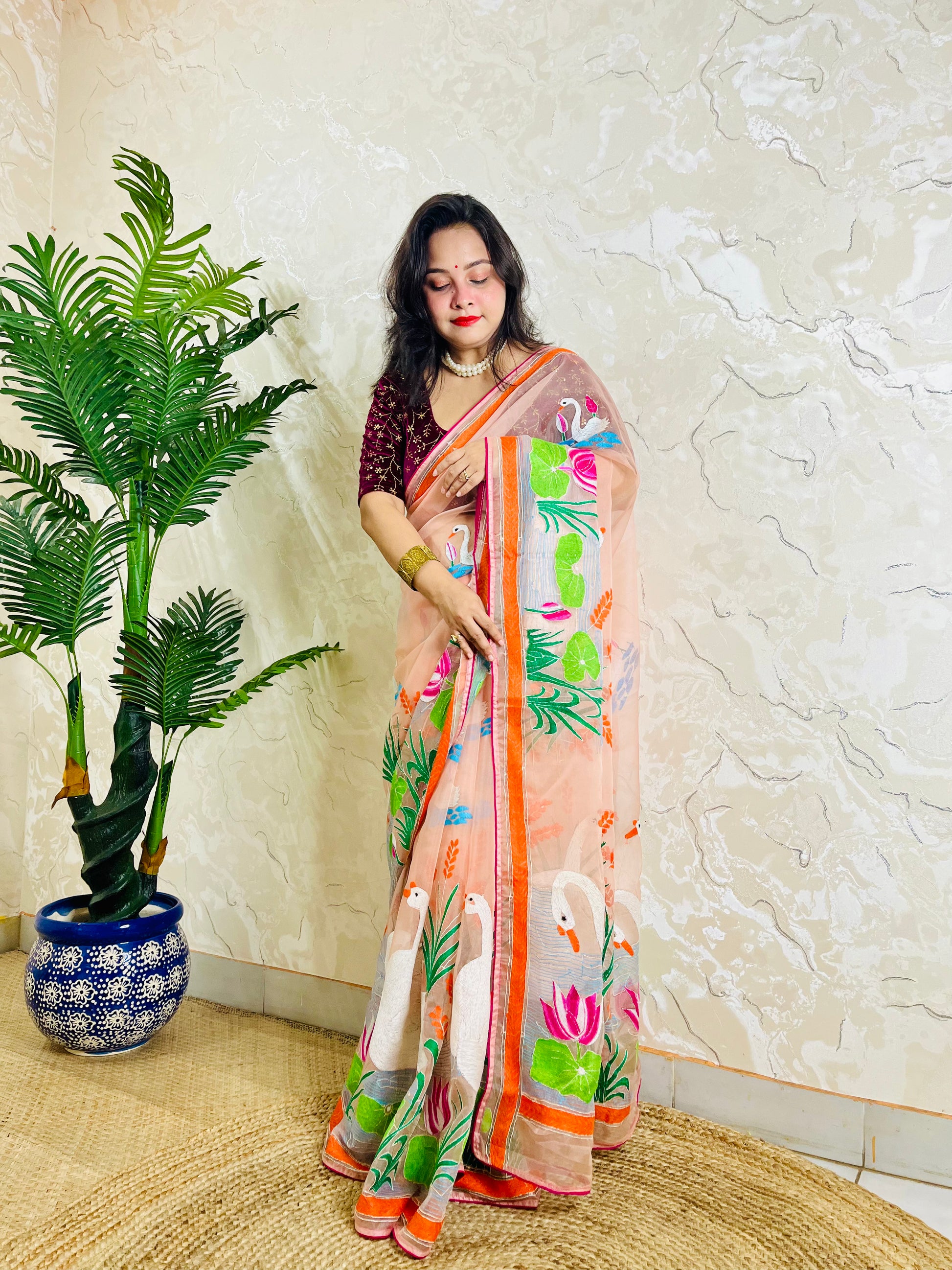 Peach-pink Kantha stitch organza saree with hand-embroidered swan and lotus motif, back standing pallu view
