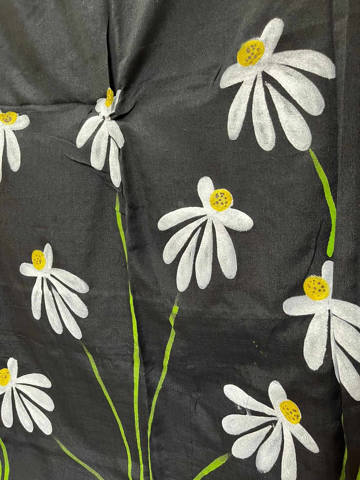A woman draped in a black mul mul cotton saree, showcasing stunning hand-painted floral designs.