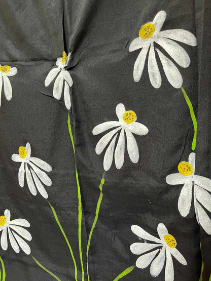 A woman draped in a black mul mul cotton saree, showcasing stunning hand-painted floral designs.