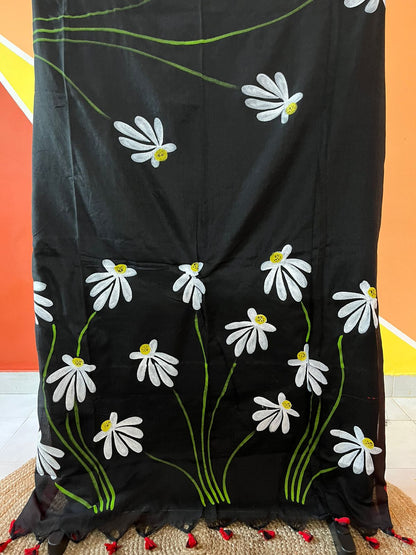 A woman draped in a black mul mul cotton saree, showcasing stunning hand-painted floral designs.