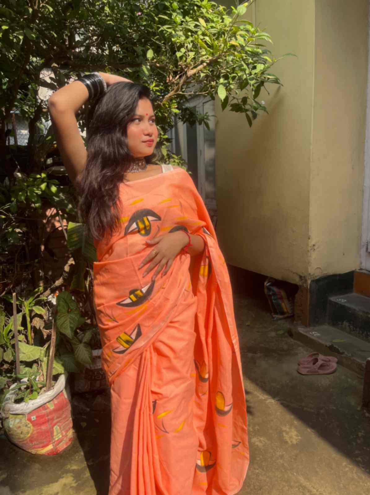 Stylish woman in Fluorescent Peach mul-cotton saree showcasing Desi Aadat’s handwoven design