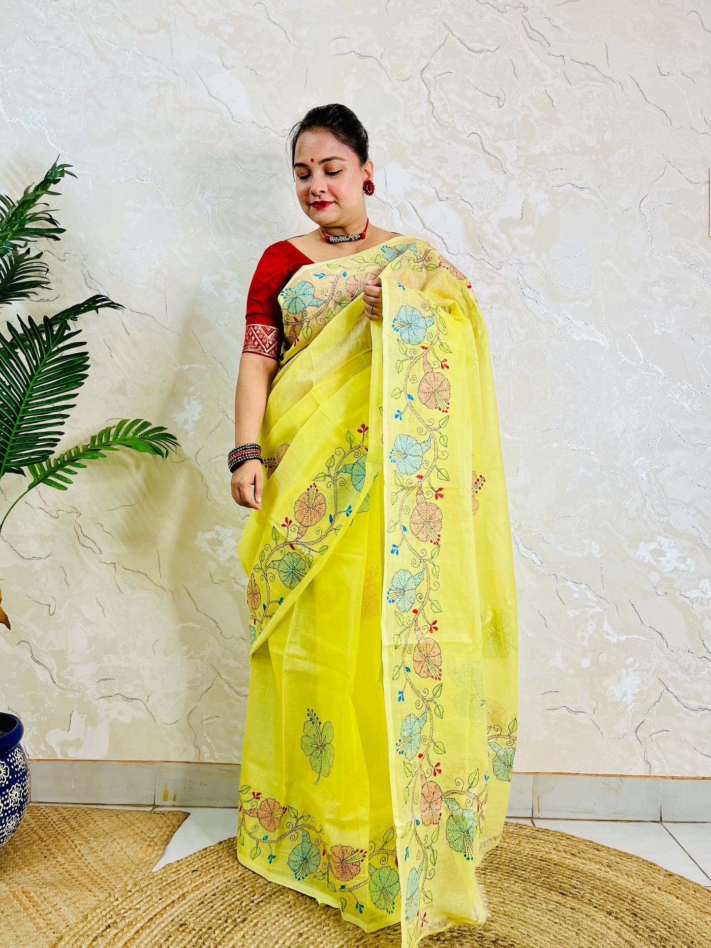 Front standing view of pastel yellow semi Tussar saree with hibiscus vine embroidery