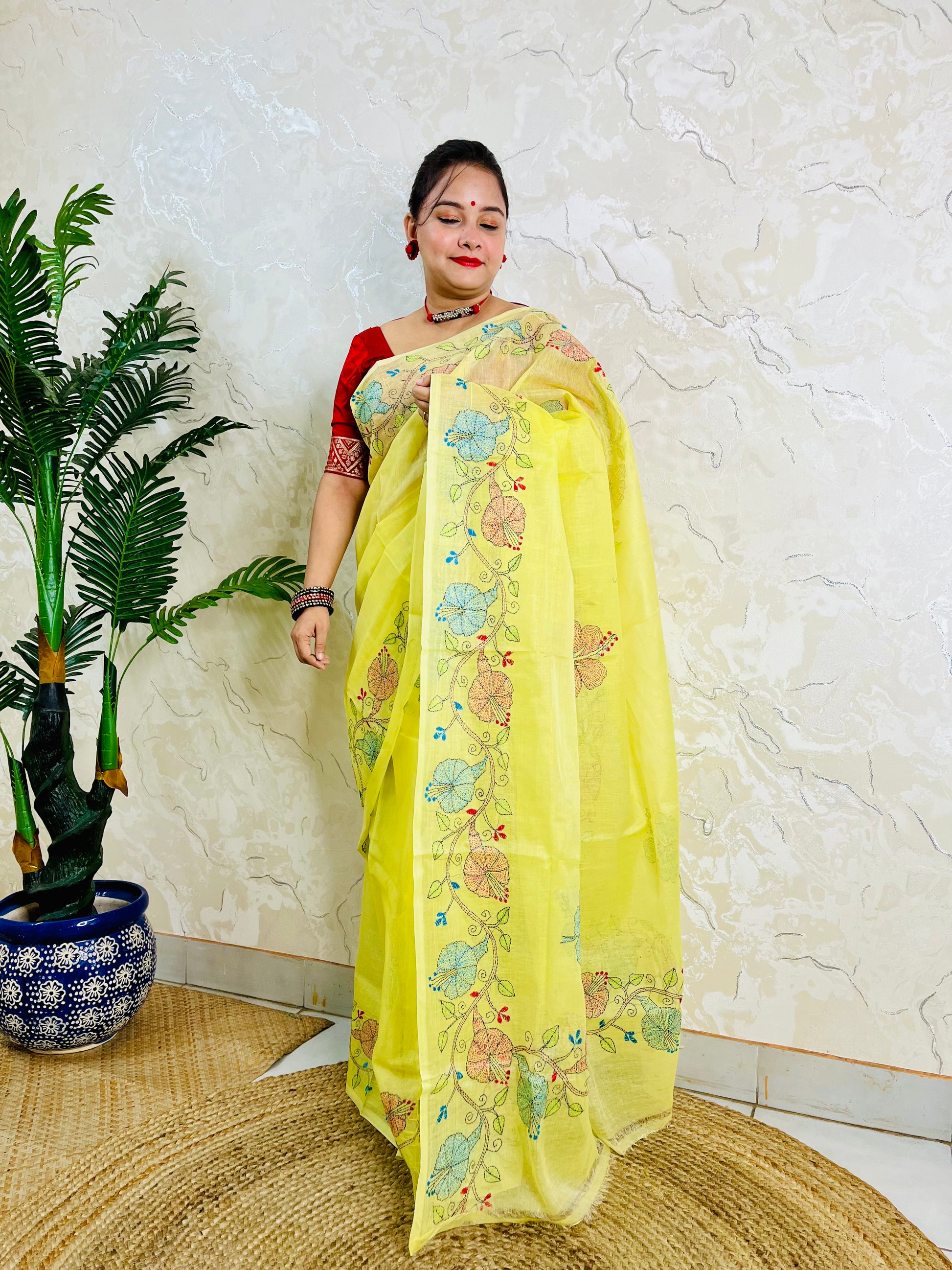 Front standing view of pastel yellow semi Tussar saree with hibiscus vine embroidery