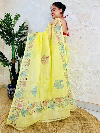 Woman standing in pastel yellow Tussar silk saree with floral Kantha embroidery