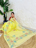 Woman seated in pastel yellow Kantha stitch Tussar silk saree, pallu draped