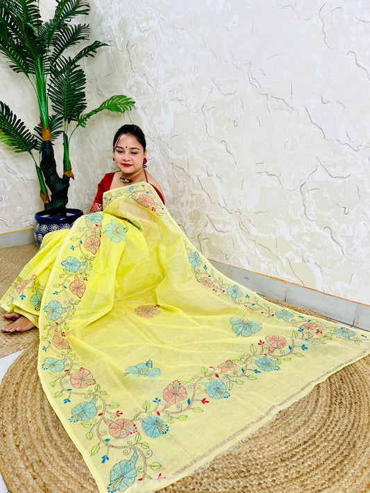 Woman seated in pastel yellow Kantha stitch Tussar silk saree, pallu draped