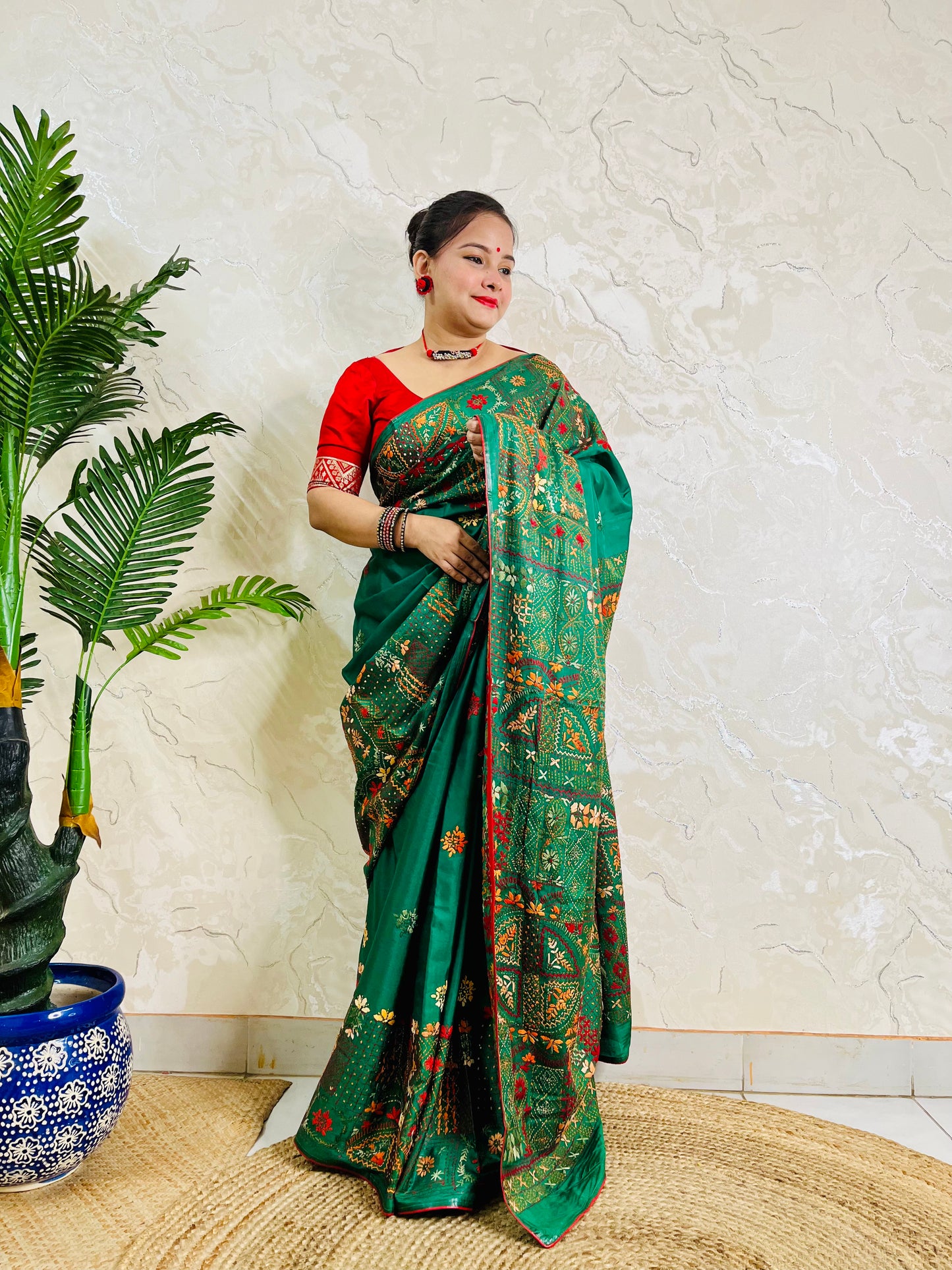 Woman standing in emerald green Bangalore silk saree with Lambani embroidery