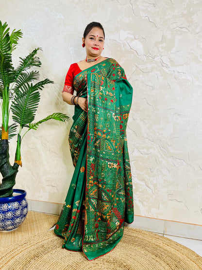 Woman standing in emerald green Bangalore silk saree with Lambani embroidery