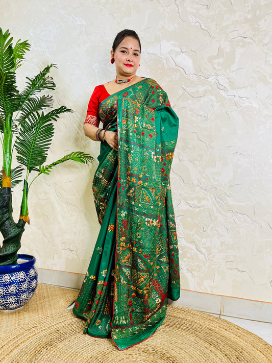 Woman standing in emerald green Bangalore silk saree with Lambani embroidery
