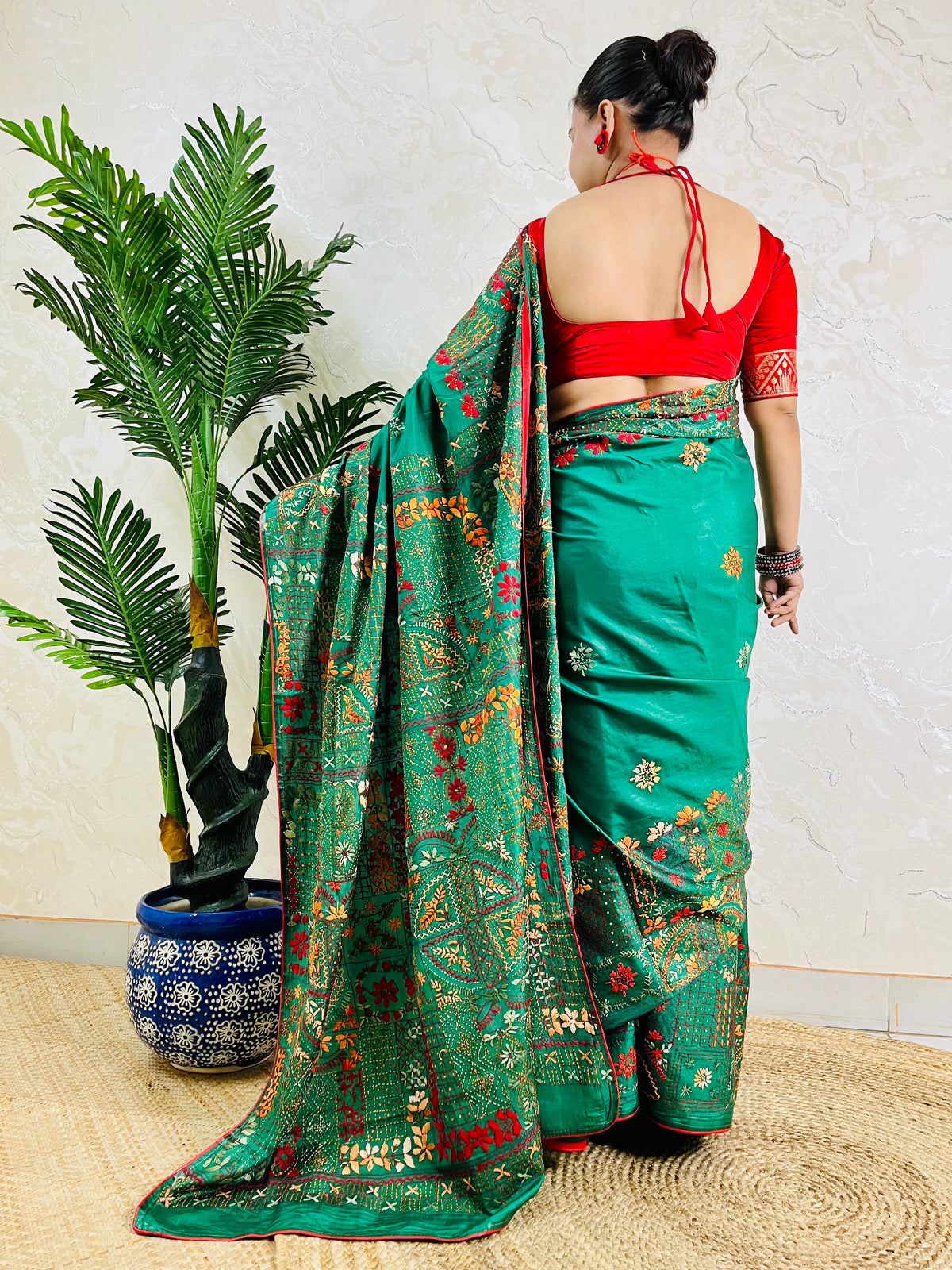 Back standing view of emerald green Lambani saree, pallu draped over shoulder