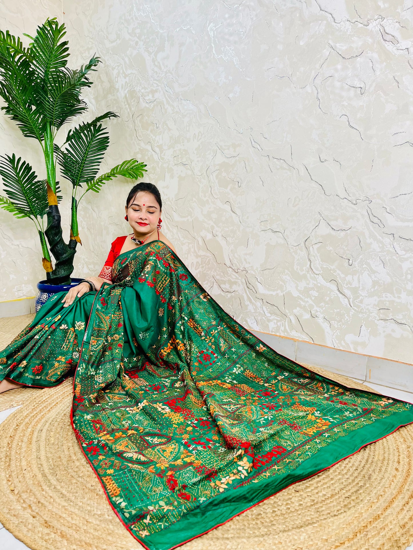 Emerald green Lambani hand stitch saree with gold thread embroidery, seated pallu view
