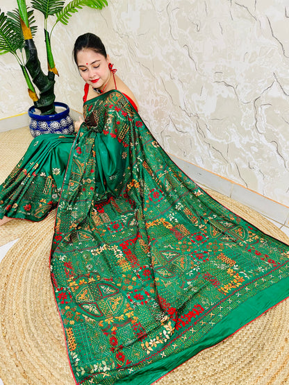 Emerald green Lambani hand stitch saree with gold thread embroidery, seated pallu view
