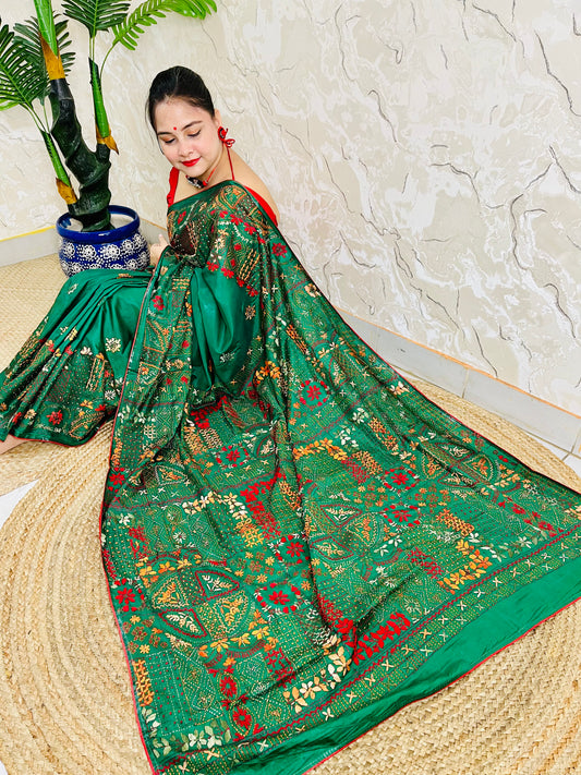 Emerald green Lambani hand stitch saree with gold thread embroidery, seated pallu view