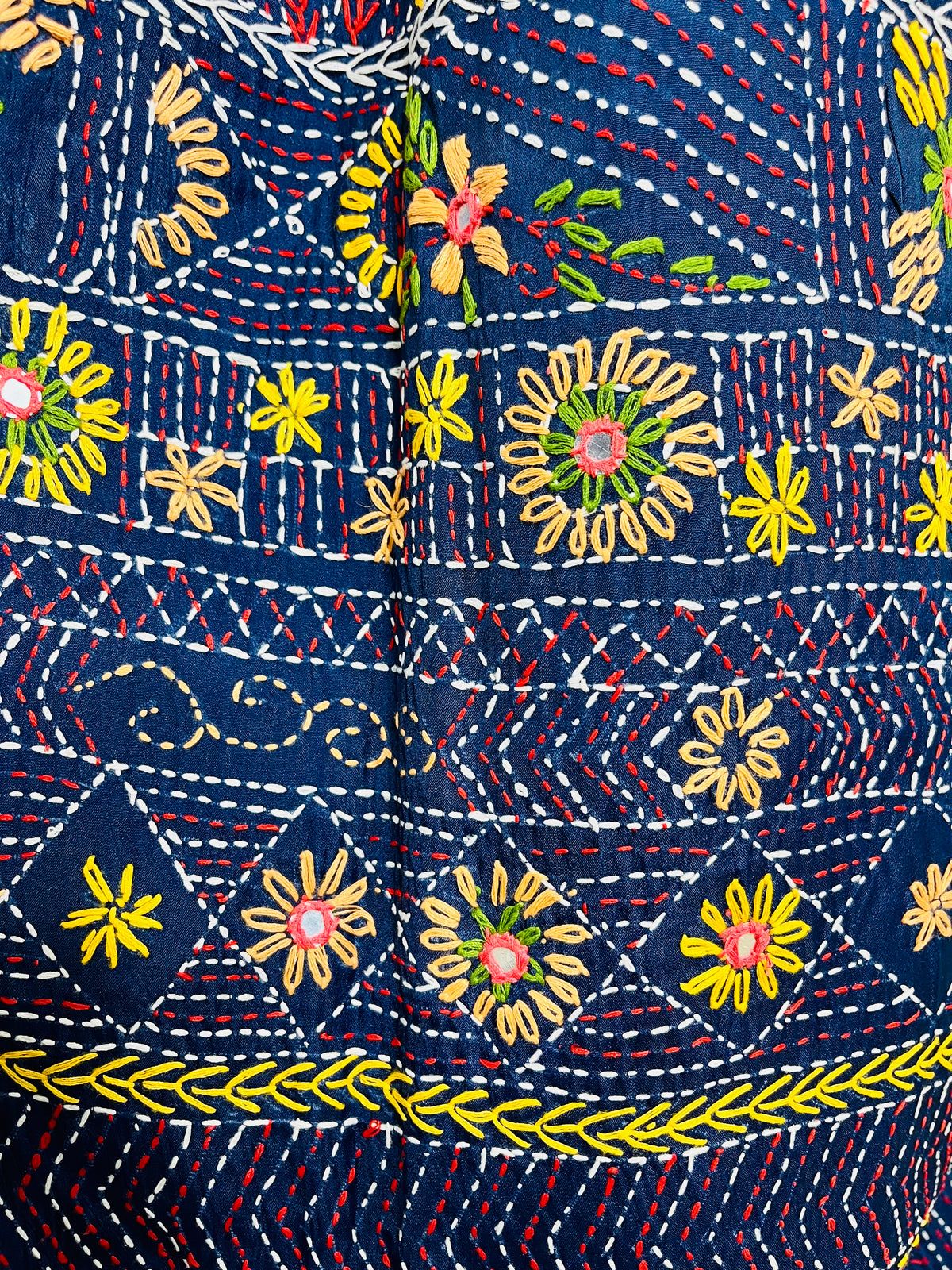 Close-up detail of arch pattern Lambani embroidery on deep indigo silk saree