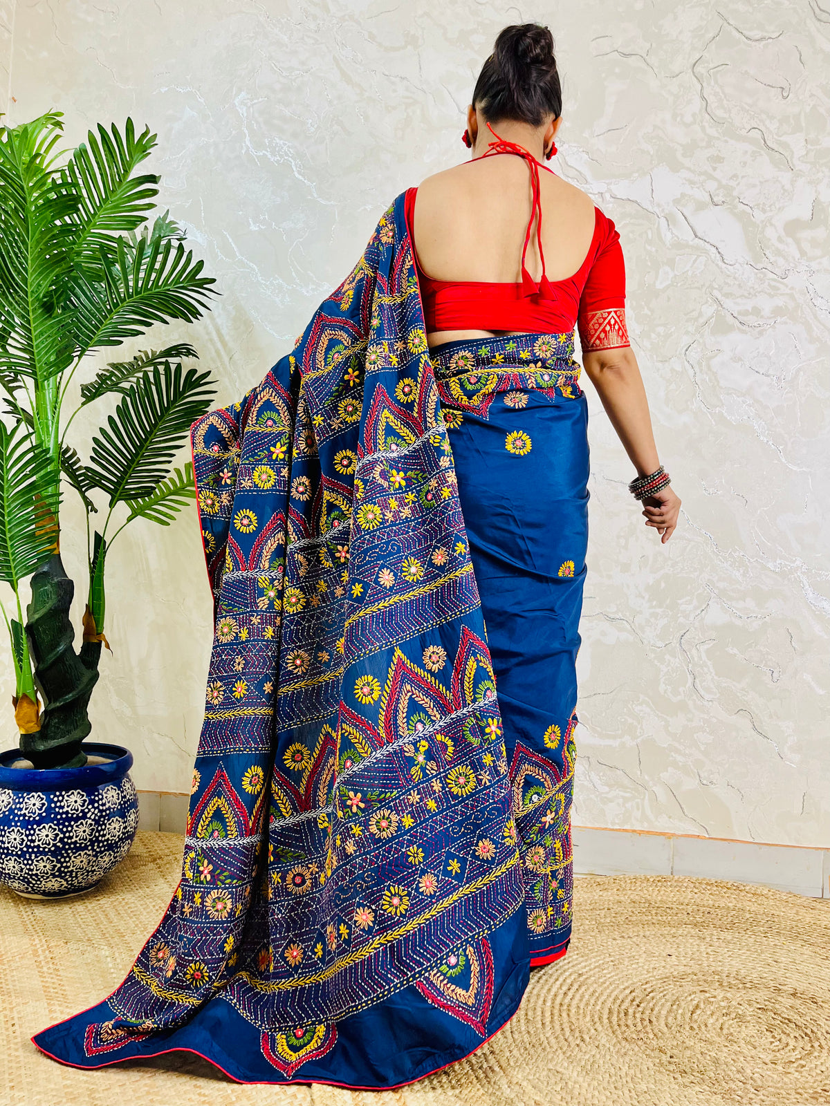 Deep indigo Lambani saree with red and gold arch motif embroidery, back standing view