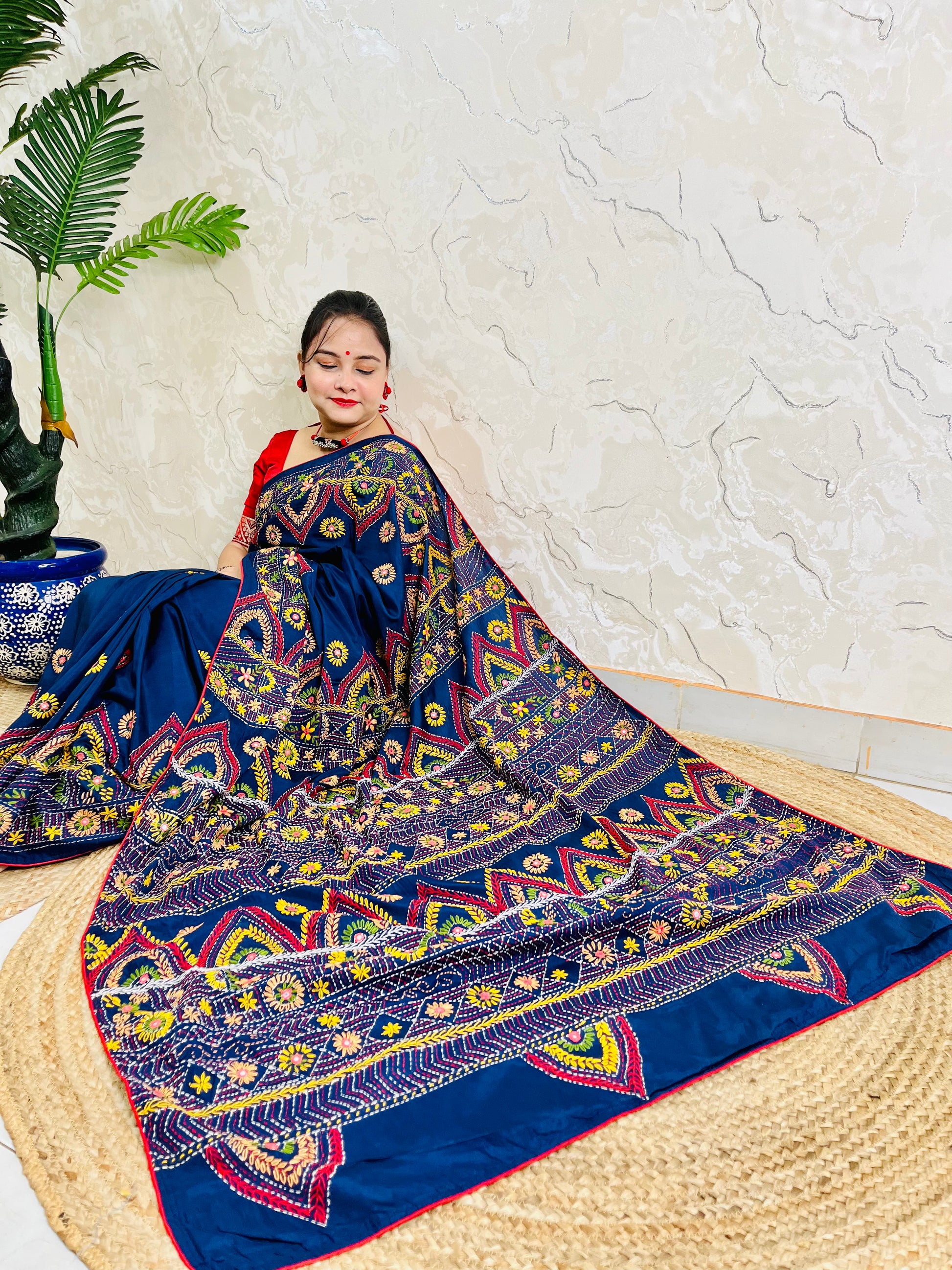 Woman seated in deep indigo Bangalore silk saree with Lambani hand embroidery