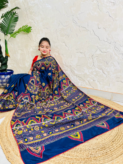 Woman seated in deep indigo Bangalore silk saree with Lambani hand embroidery