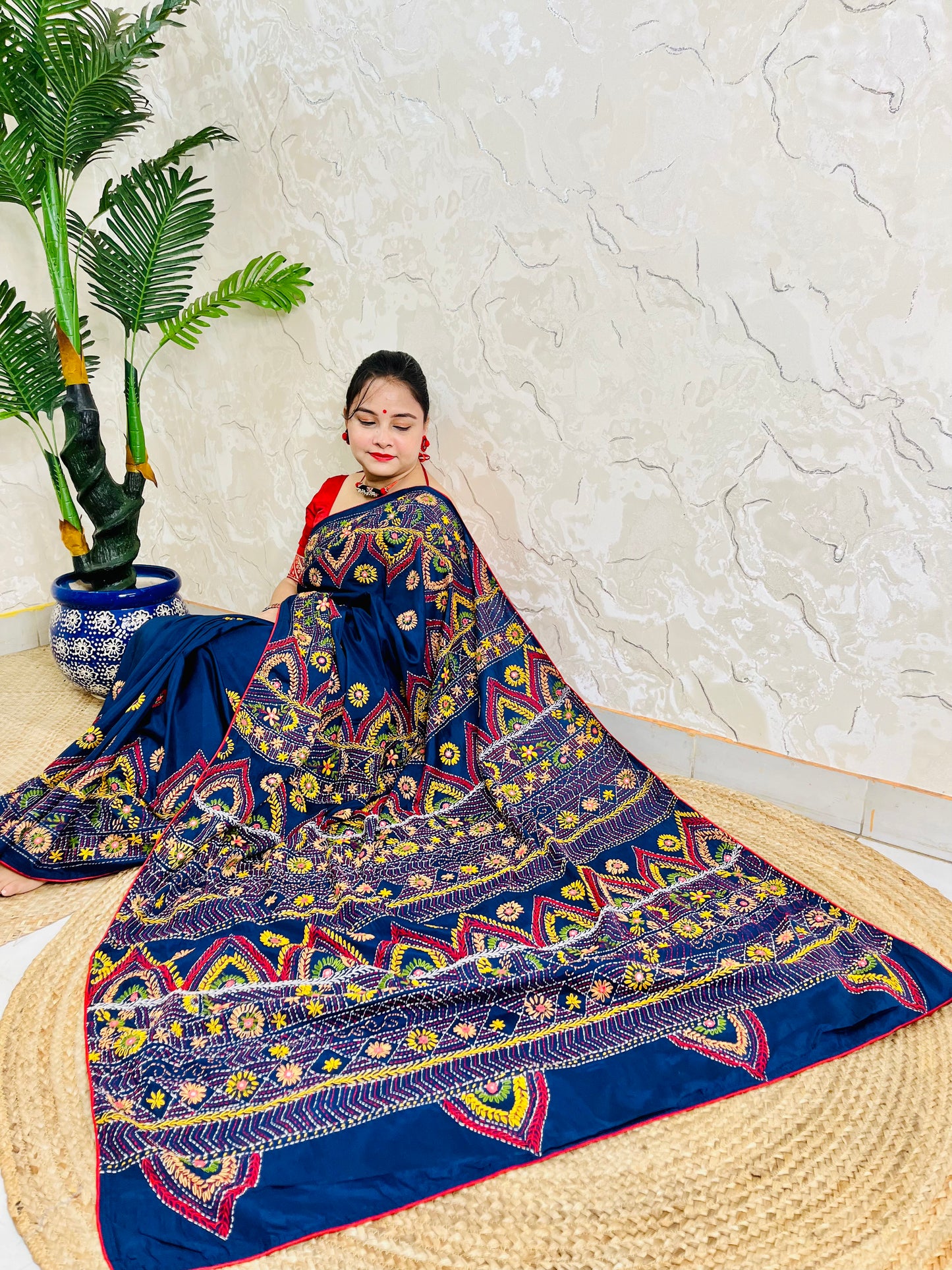 Woman seated in deep indigo Bangalore silk saree with Lambani hand embroidery