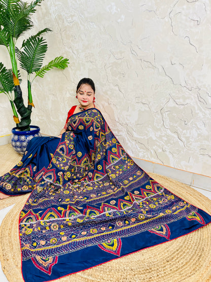 Woman seated in deep indigo Bangalore silk saree with Lambani hand embroidery