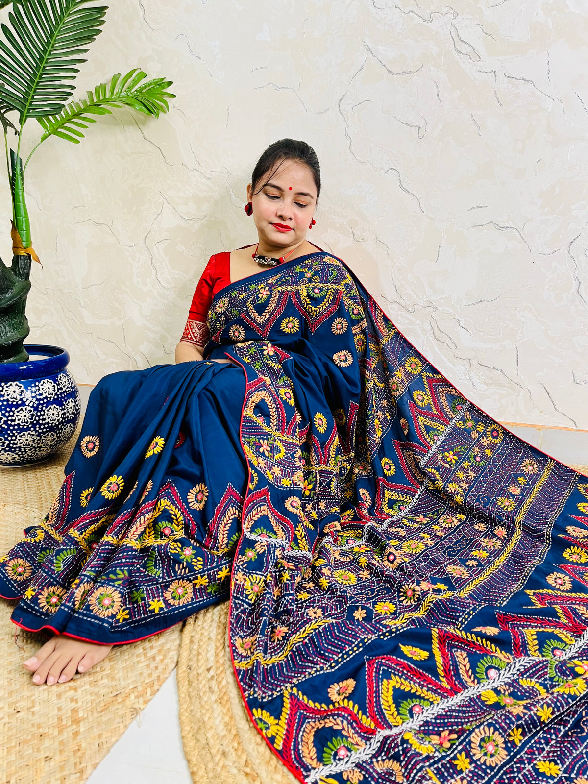 Woman seated in deep indigo Bangalore silk saree with Lambani hand embroidery