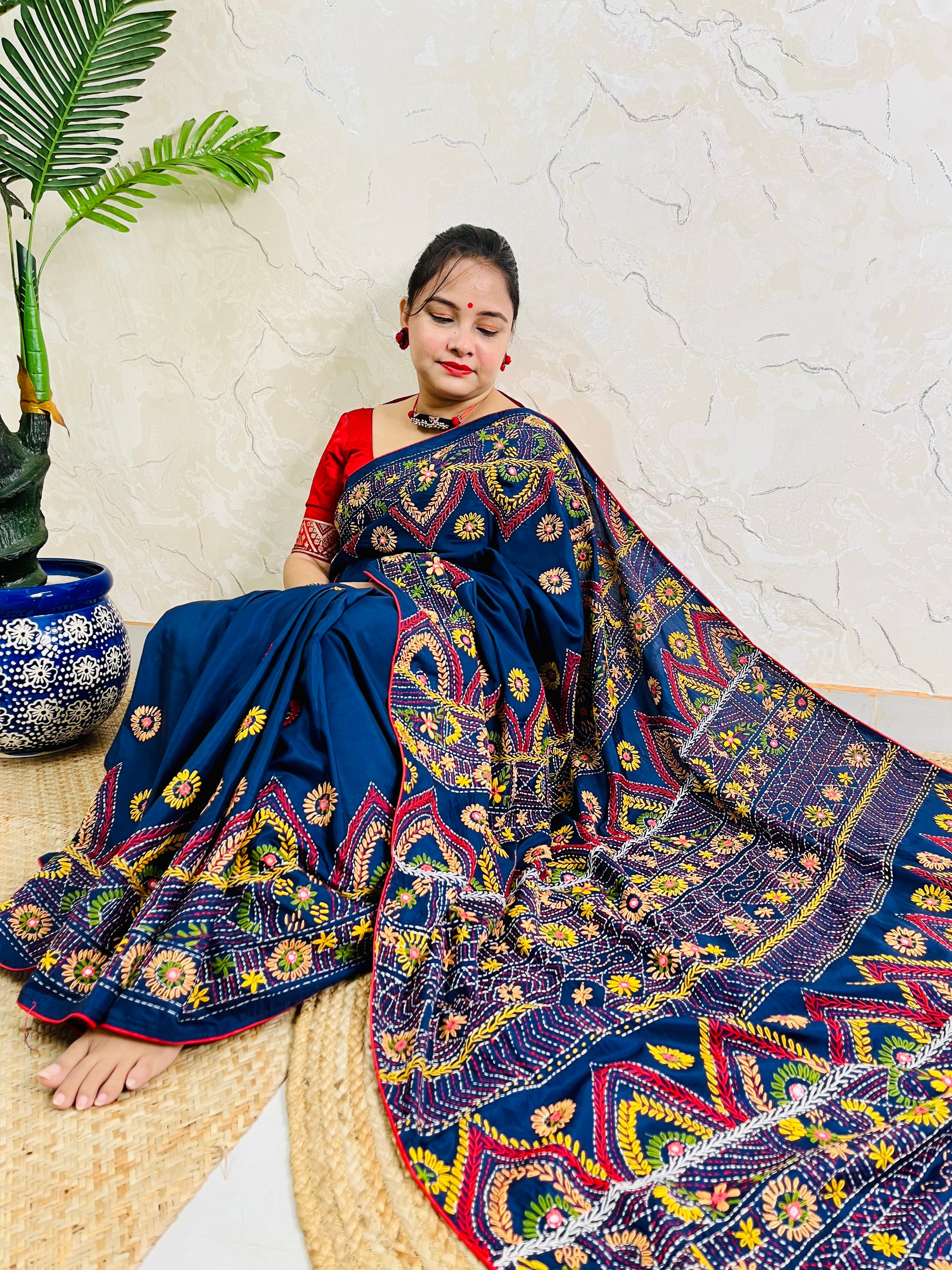 Woman seated in deep indigo Bangalore silk saree with Lambani hand embroidery