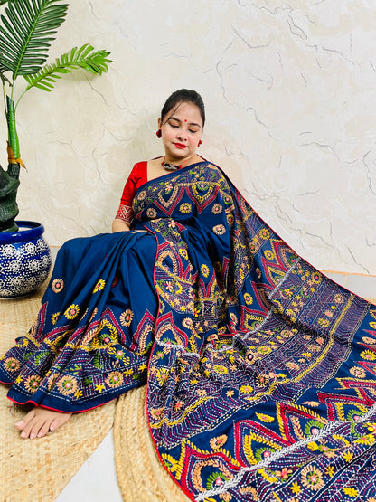 Woman seated in deep indigo Bangalore silk saree with Lambani hand embroidery