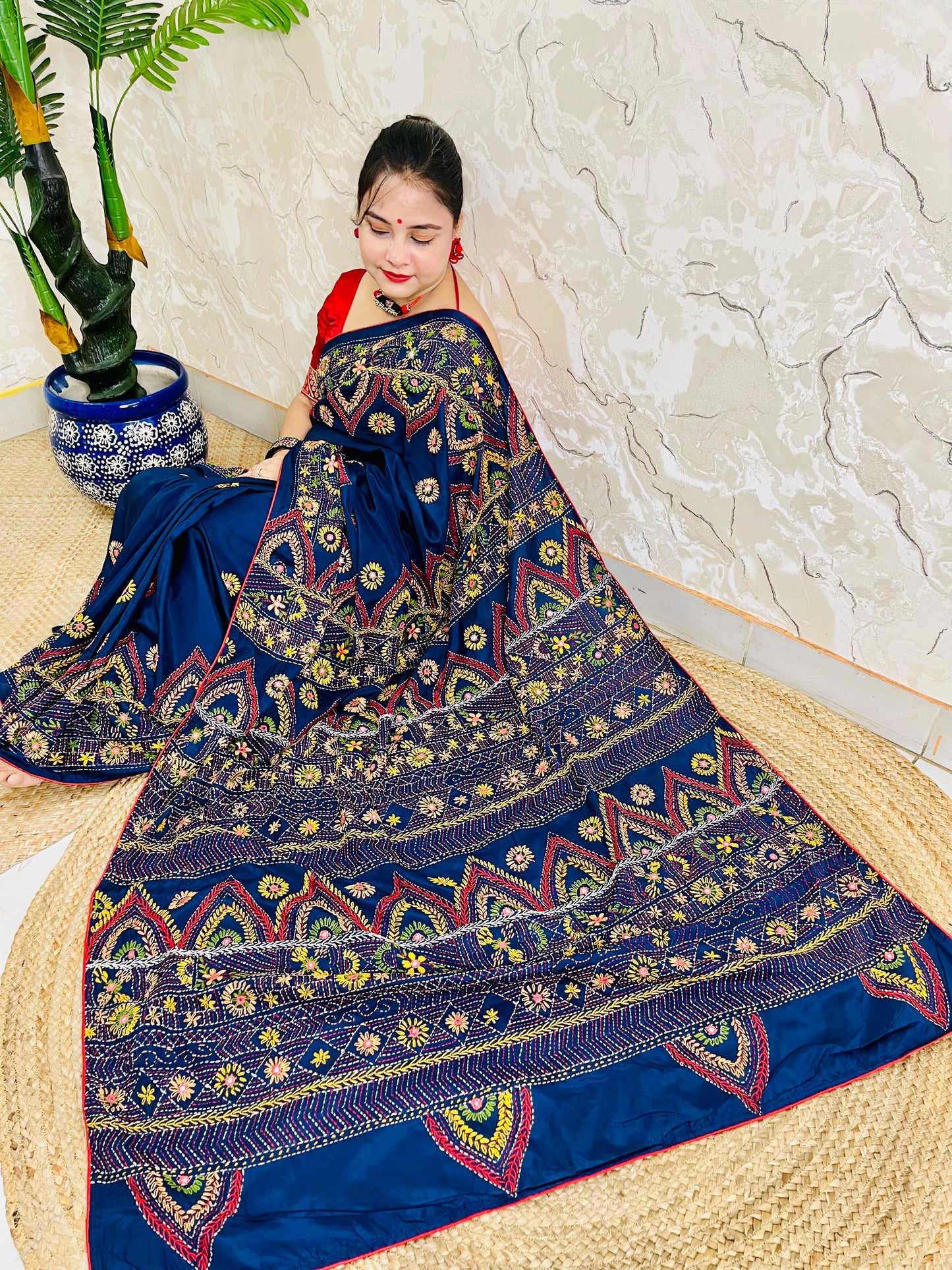 Woman seated in deep indigo Bangalore silk saree with Lambani hand embroidery