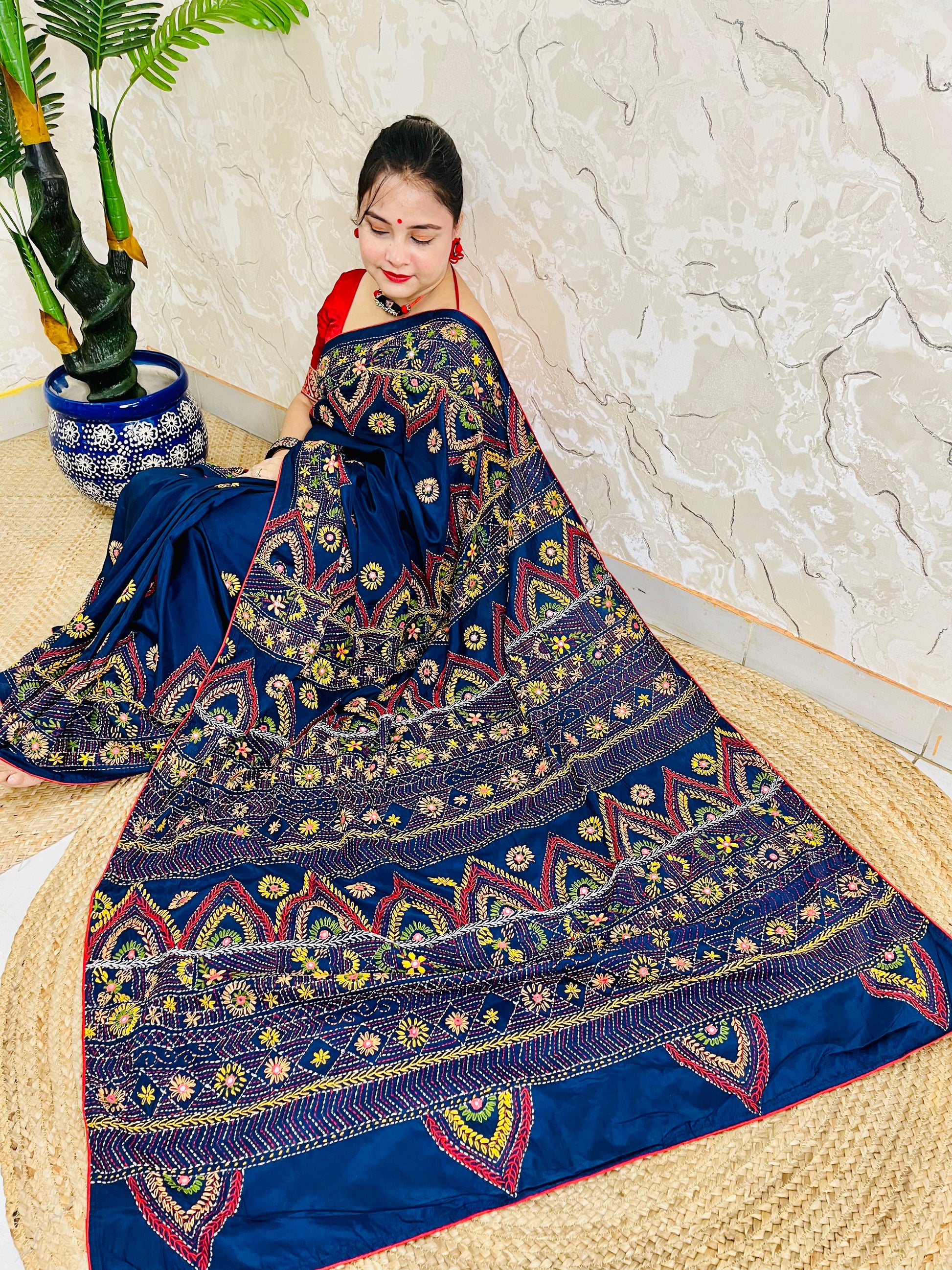 Woman seated in deep indigo Bangalore silk saree with Lambani hand embroidery
